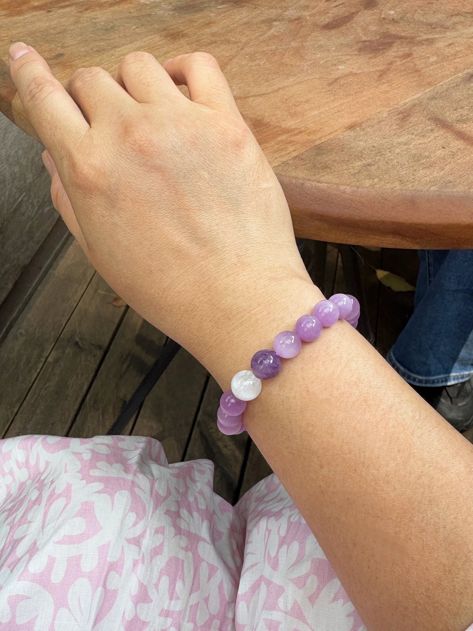 Front view of a Kunzite, Charoite & White Phantom Quartz bracelet worn on the wrist