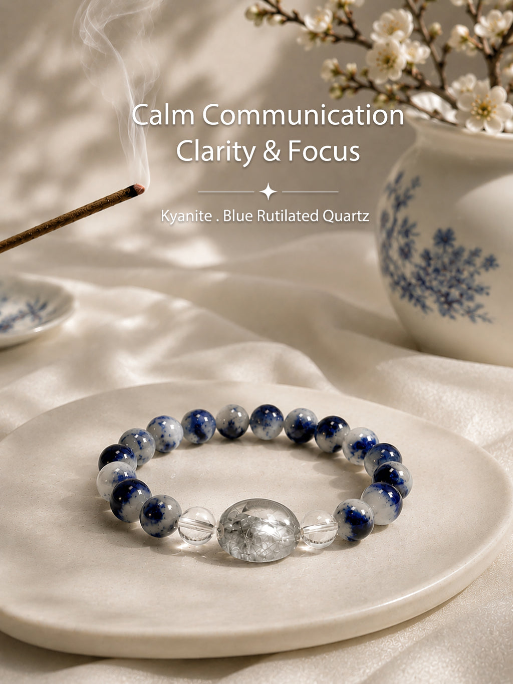 Luzzy Aura Kyanite and Blue Rutilated Quartz crystal bracelet resting beside an elegant blue-and-white porcelain vase, representing calm, clarity, and Eastern-inspired serenity.
