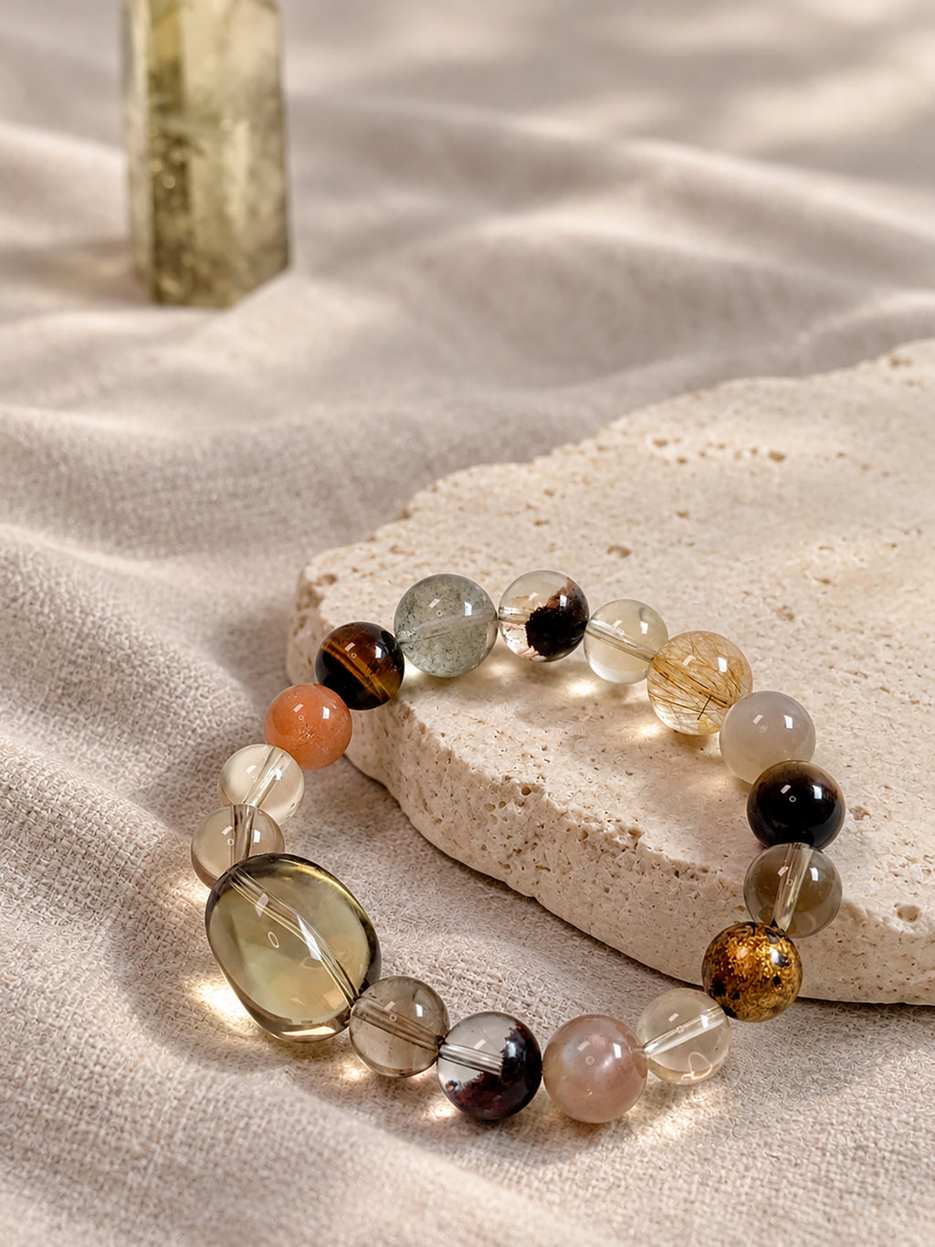 Natural Smoky Quartz, Phantom Quartz and Copper Rutilated Quartz Bracelet styled in a warm, earthy setting, highlighting its autumn-inspired colors.