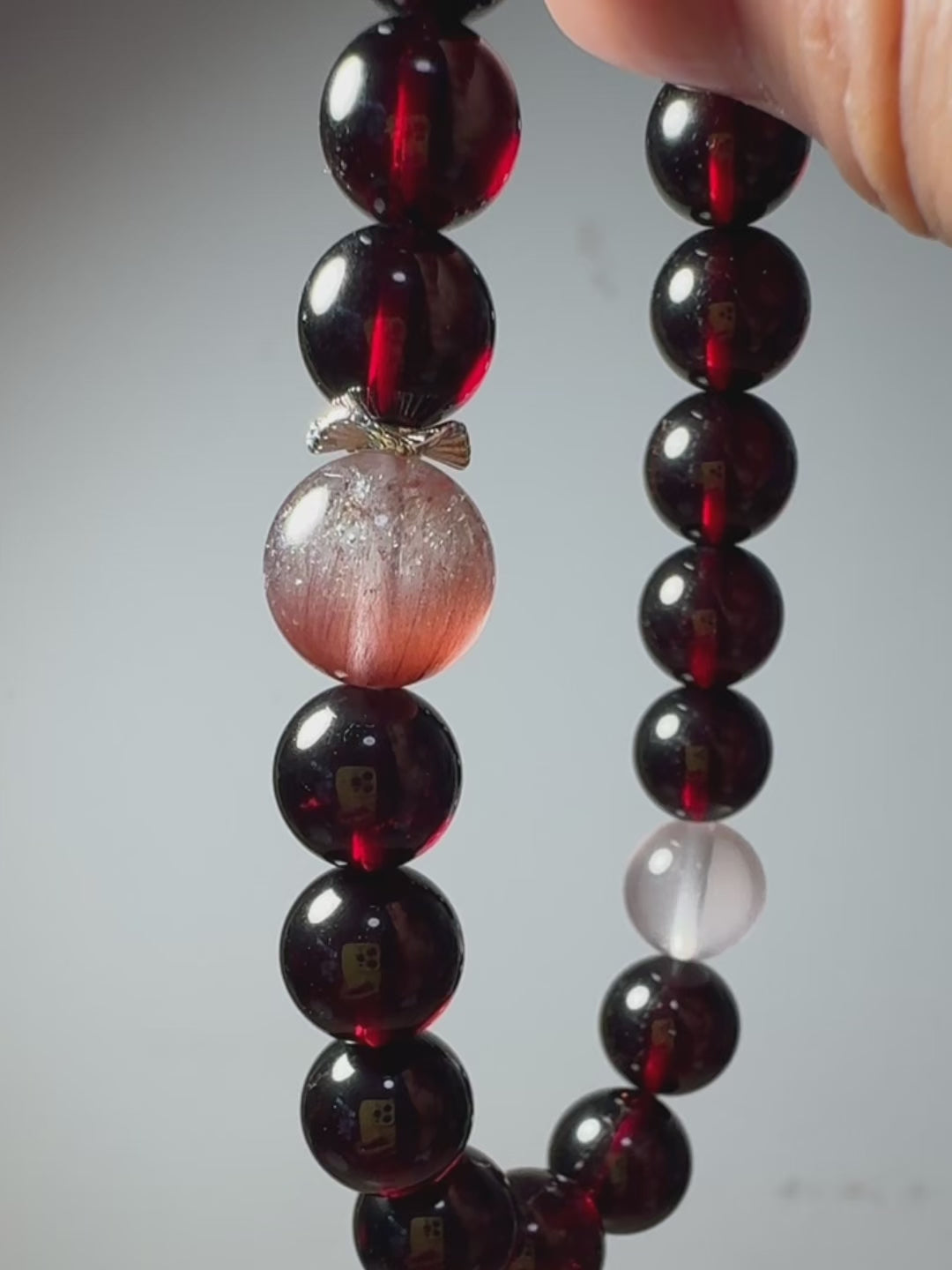 Video of garnet and pink rabbit hair quartz bracelet showing natural crystal details and sparkle