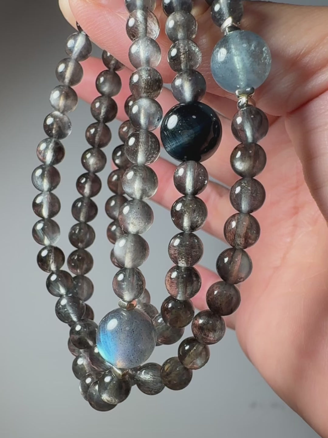 Video showcasing Aquamarine and Biotite crystal bracelet with Blue Tiger's Eye and Labradorite, highlighting overall design and natural crystal details