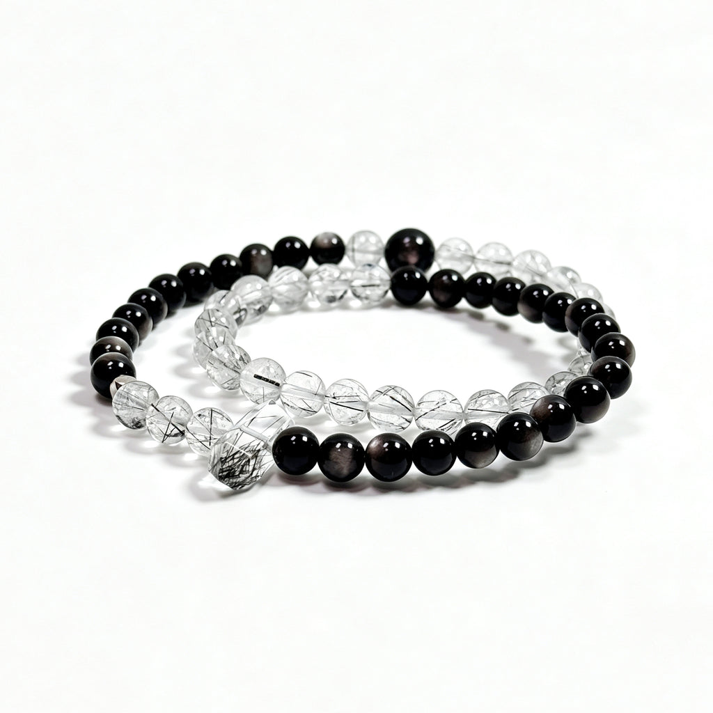 Black rutilated quartz and obsidian bracelet on clean white background for protection and stability