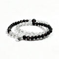 Black rutilated quartz and obsidian bracelet on clean white background for protection and stability