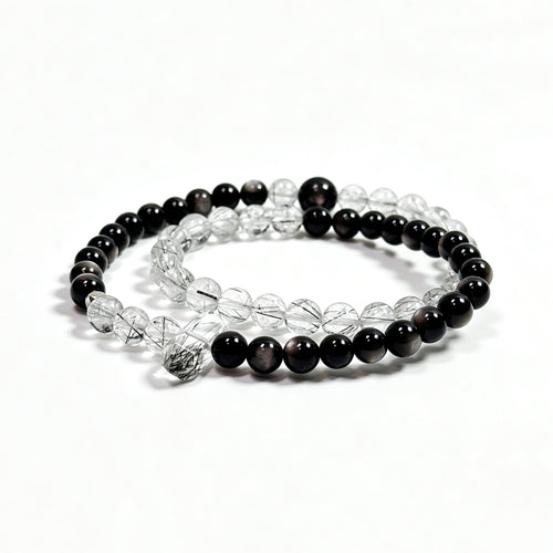 Black rutilated quartz and obsidian bracelet on clean white background for protection and stability