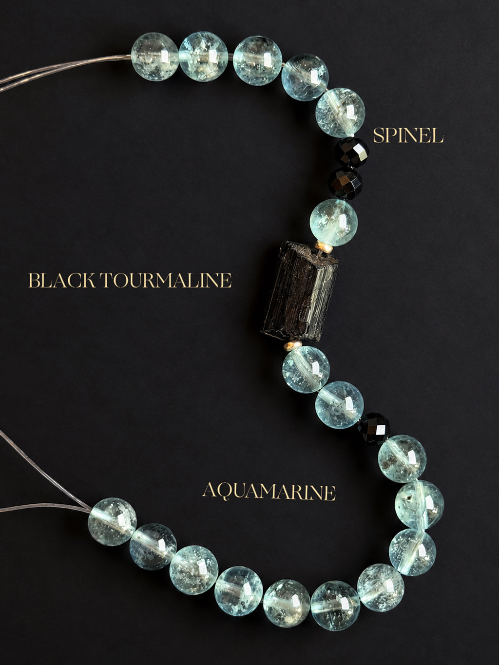 Rare natural green aquamarine bracelet with visible mineral inclusions, a raw black tourmaline centerpiece, and faceted black spinel beads on a pure white background.