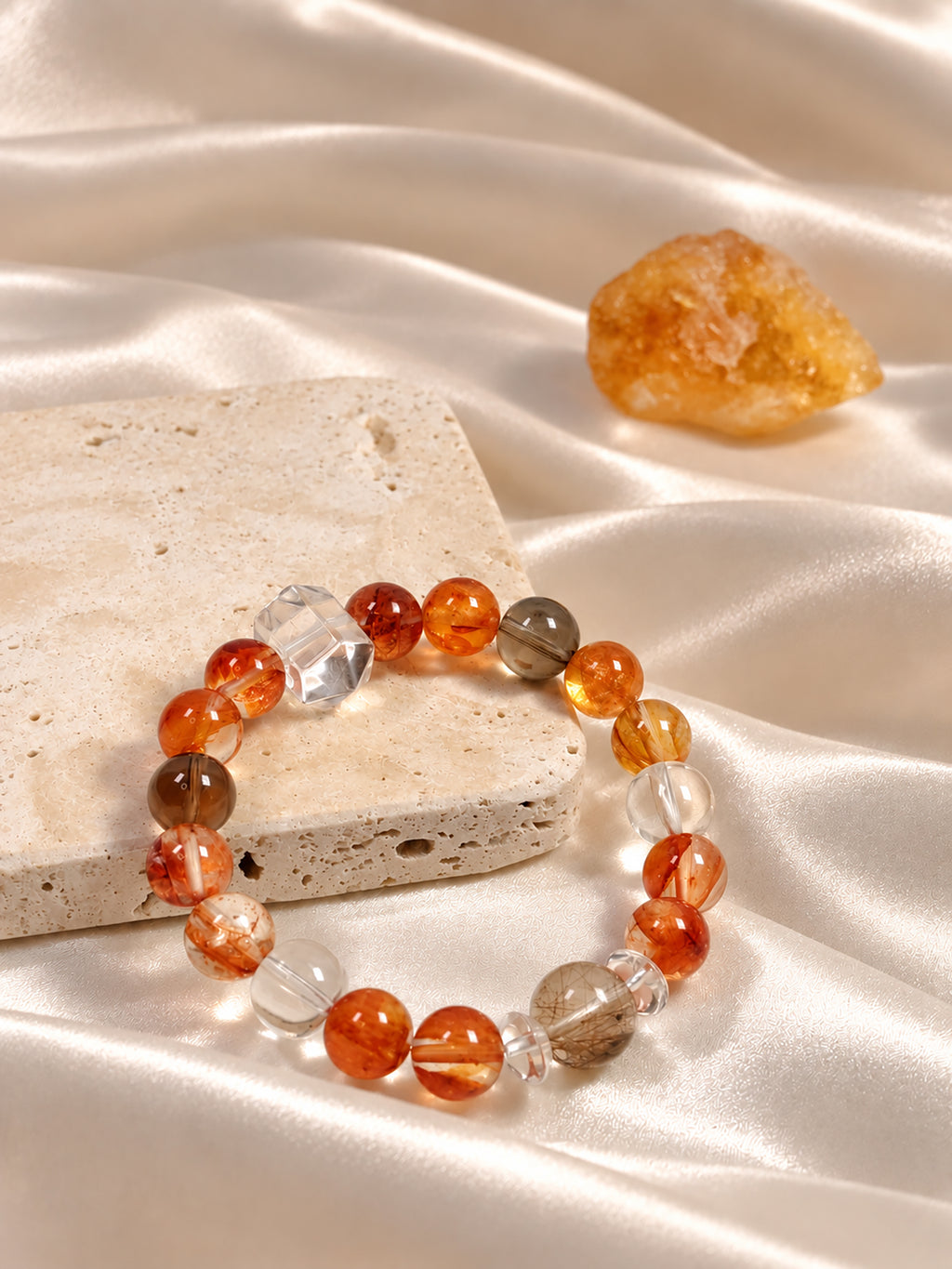  Red Hematoid Quartz bracelet with highly transparent Silver Rutilated Quartz, Smoky Quartz and Clear Quartz, showcasing natural mineral patterns in an elegant lifestyle composition.