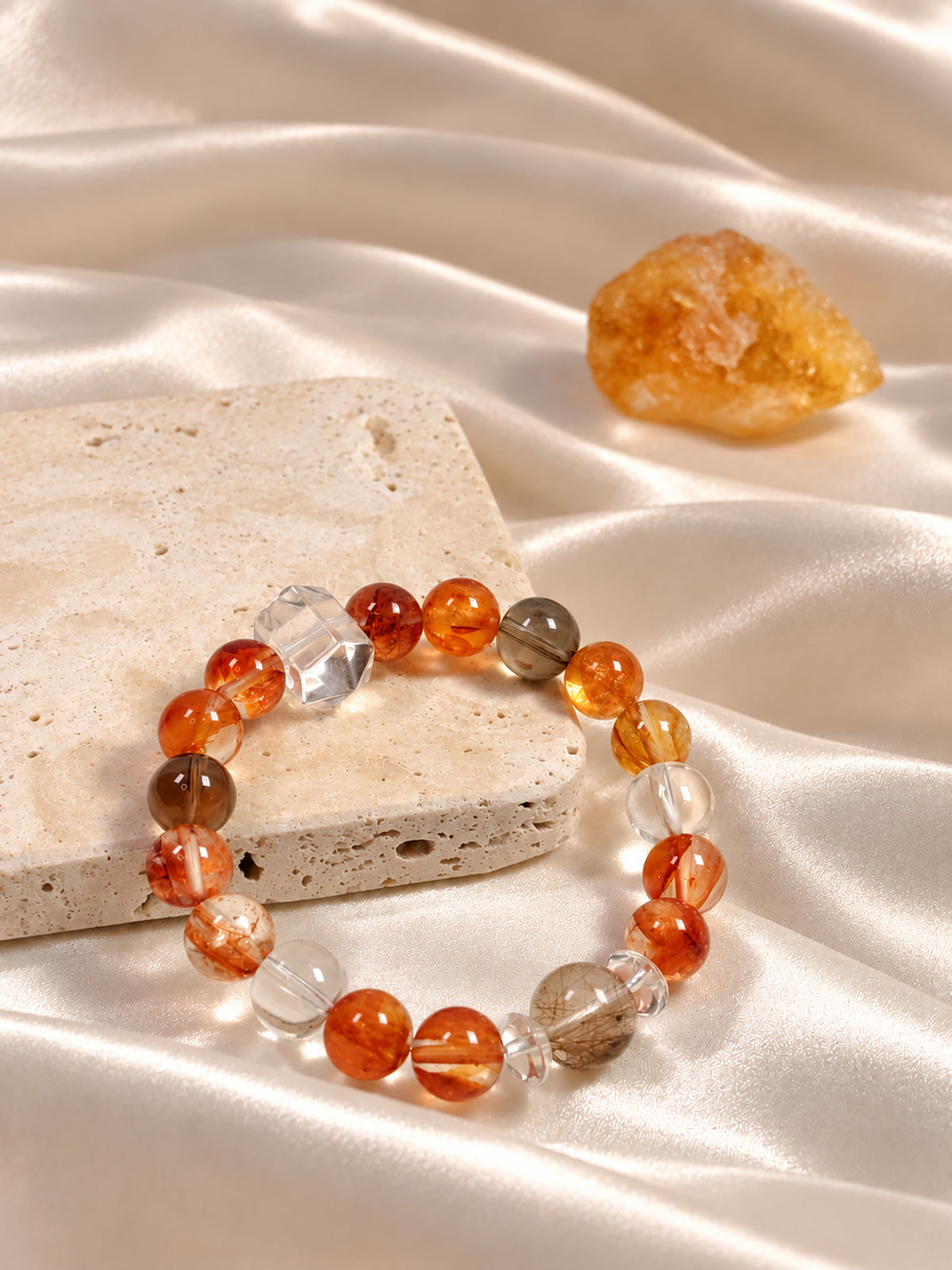  Red Hematoid Quartz bracelet with highly transparent Silver Rutilated Quartz, Smoky Quartz and Clear Quartz, showcasing natural mineral patterns in an elegant lifestyle composition.