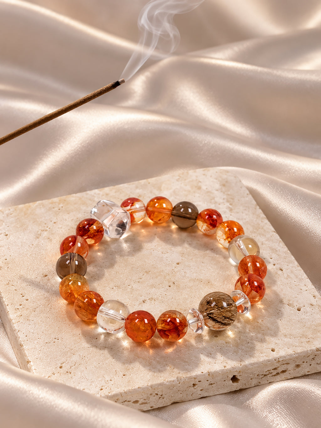  Red Hematoid Quartz bracelet with highly transparent Silver Rutilated Quartz, Smoky Quartz and Clear Quartz, showcasing natural mineral patterns in an elegant lifestyle composition.