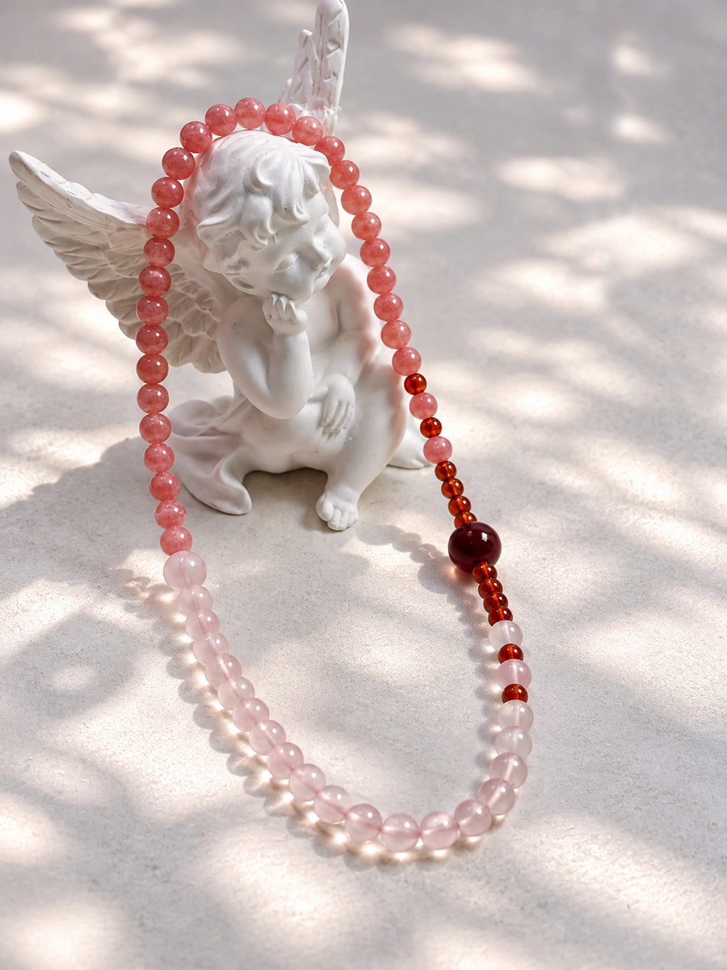 Natural Rhodochrosite, Star Rose Quartz, and Orange-Red Garnet double-wrap bracelet styled in a soft, elegant setting.