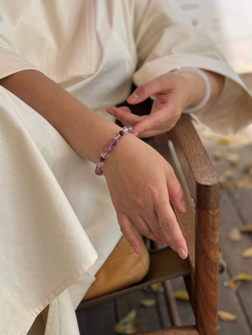 Rose quartz and Super Seven crystal bracelet worn in a relaxed slow-living setting for grounded love and emotional balance