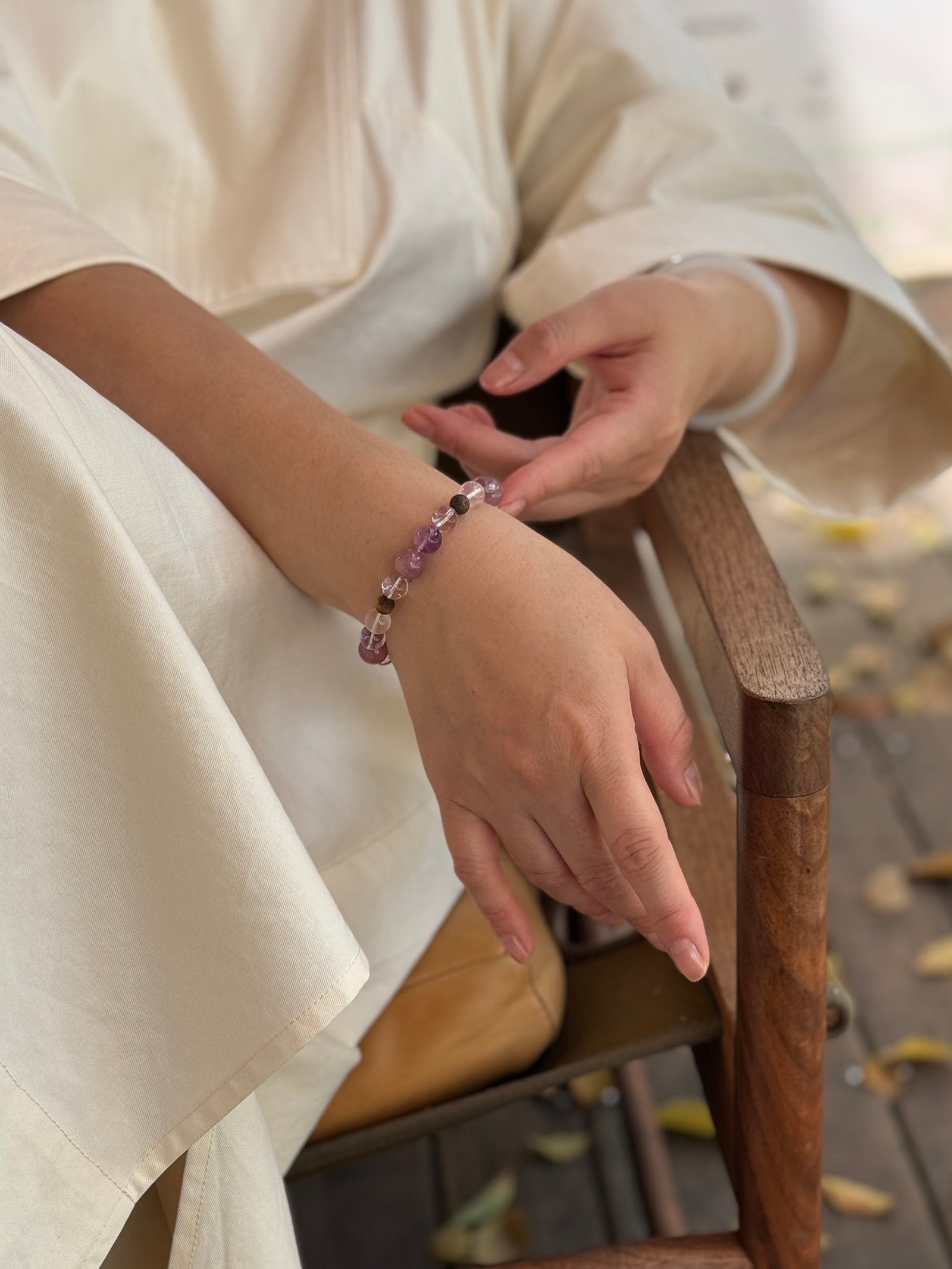 Rose quartz and Super Seven crystal bracelet worn in a relaxed slow-living setting for grounded love and emotional balance