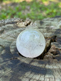 Scenic fluorite crystal sphere with tree-like landscape patterns displayed on natural wood stump showing mist-like layers and soft gradient tones
