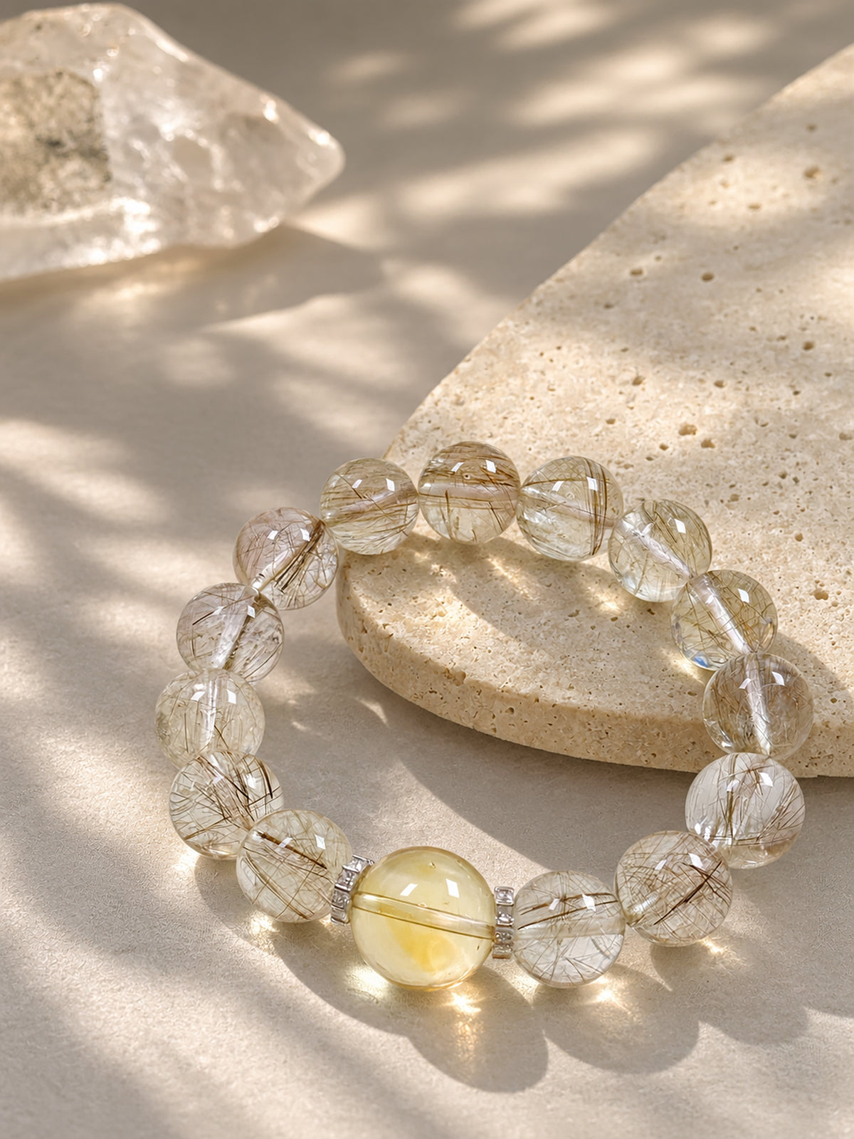 Silver Rutilated Quartz manifestation bracelet styled on meditation altar with calming spiritual objects