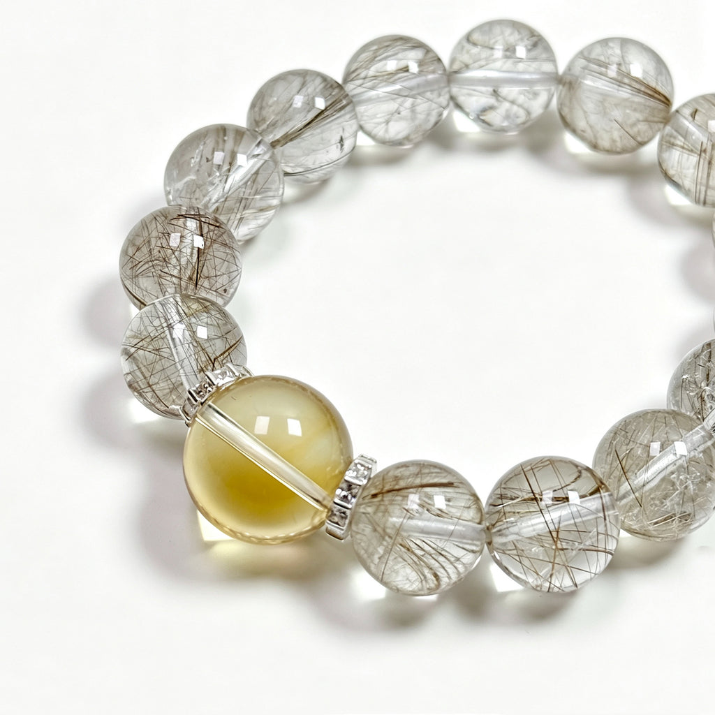 Close-up detail of Silver Rutilated Quartz manifestation crystal bracelet showing natural stone texture