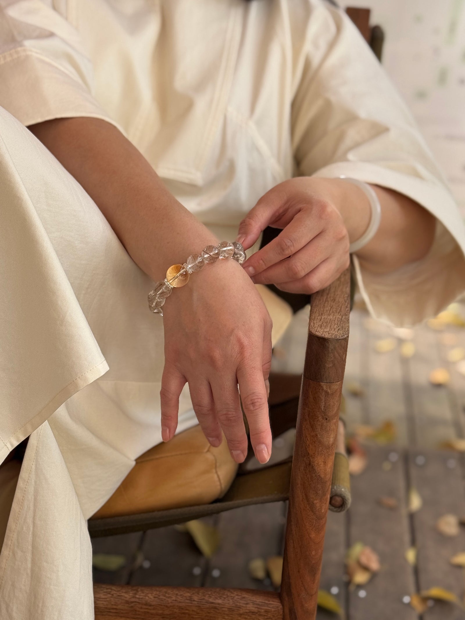Silver Rutilated Quartz manifestation crystal bracelet worn in a relaxed lifestyle setting for calm and balanced energy