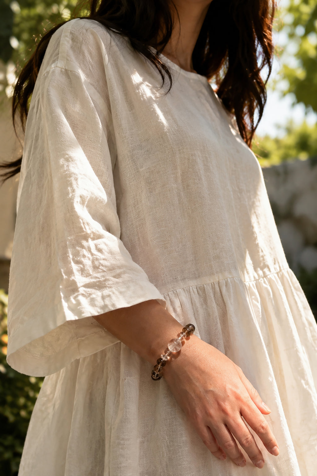 Smoky quartz and white phantom quartz bracelet worn in a relaxed lifestyle setting for grounding and balance