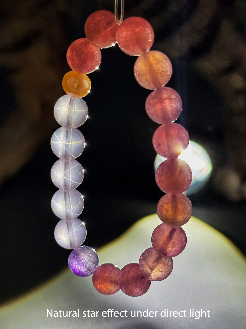 Hexagram-like natural star effect visible on Star Rose Quartz beads under strong direct light