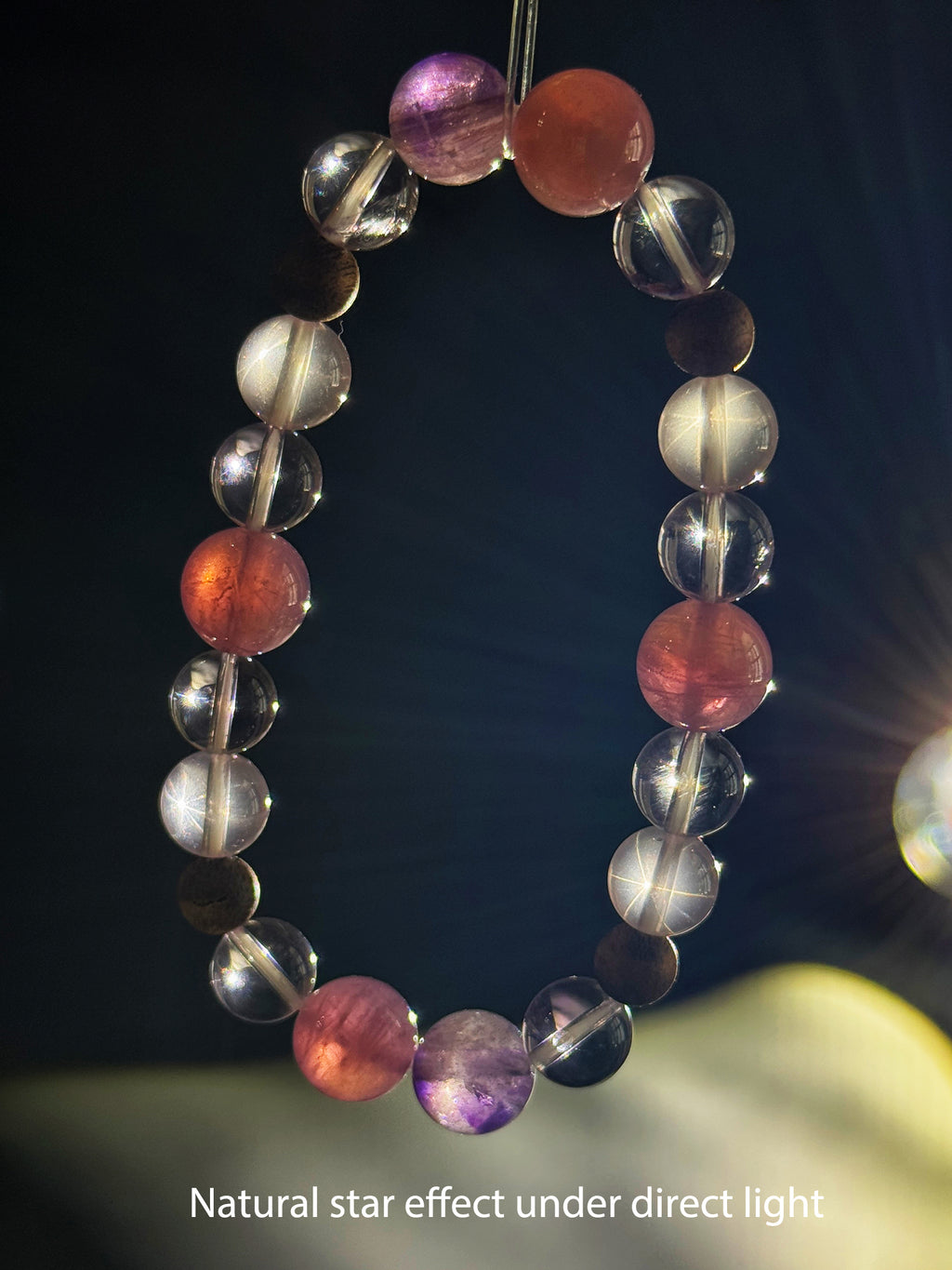 Star Rose Quartz bracelet showing its natural star effect under focused direct lighting