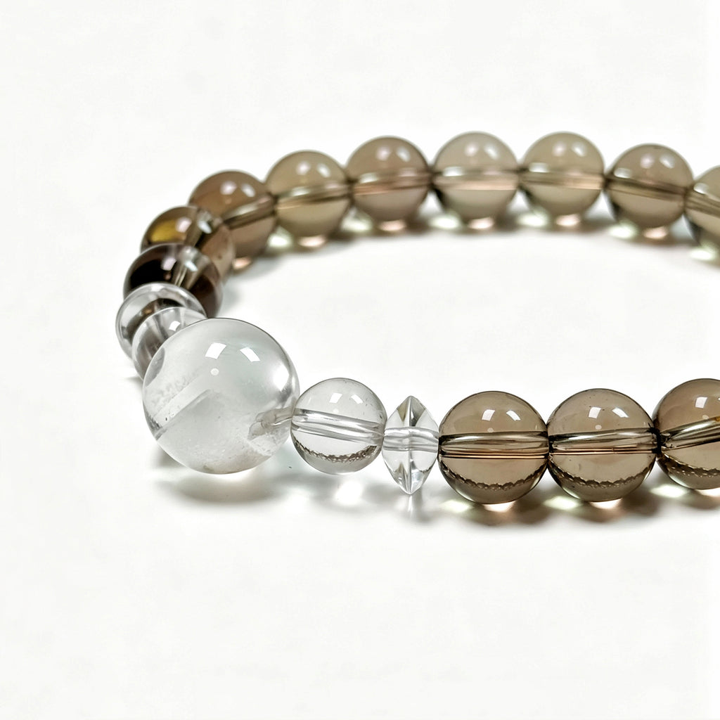 Close-up detail of white phantom quartz focal bead and smoky quartz bracelet showing natural crystal texture